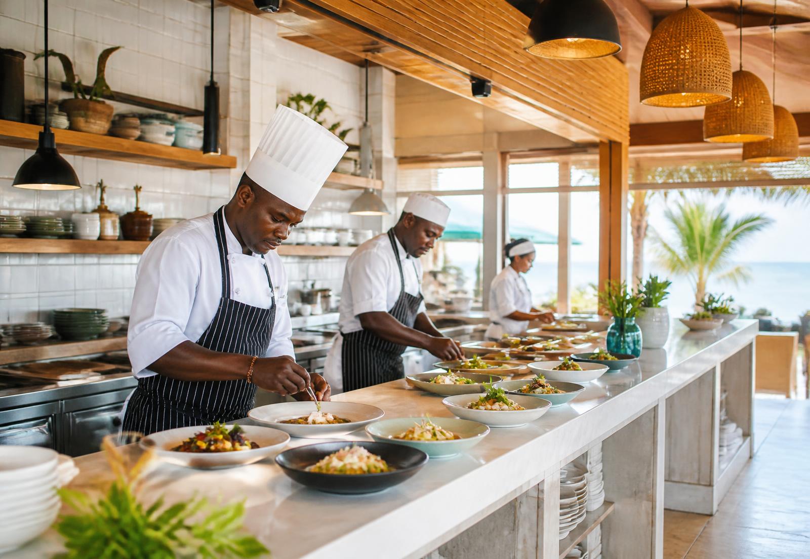Koks werken rustig in een lichte open keuken van een resort